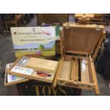 An artists easel with integral paint box & paints; another cased set of artists pastels & paints;