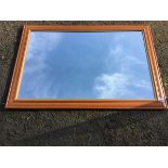 A contemporary pine framed mirror, the cushion moulded frame with gilt inner border. (38.5in x 26.