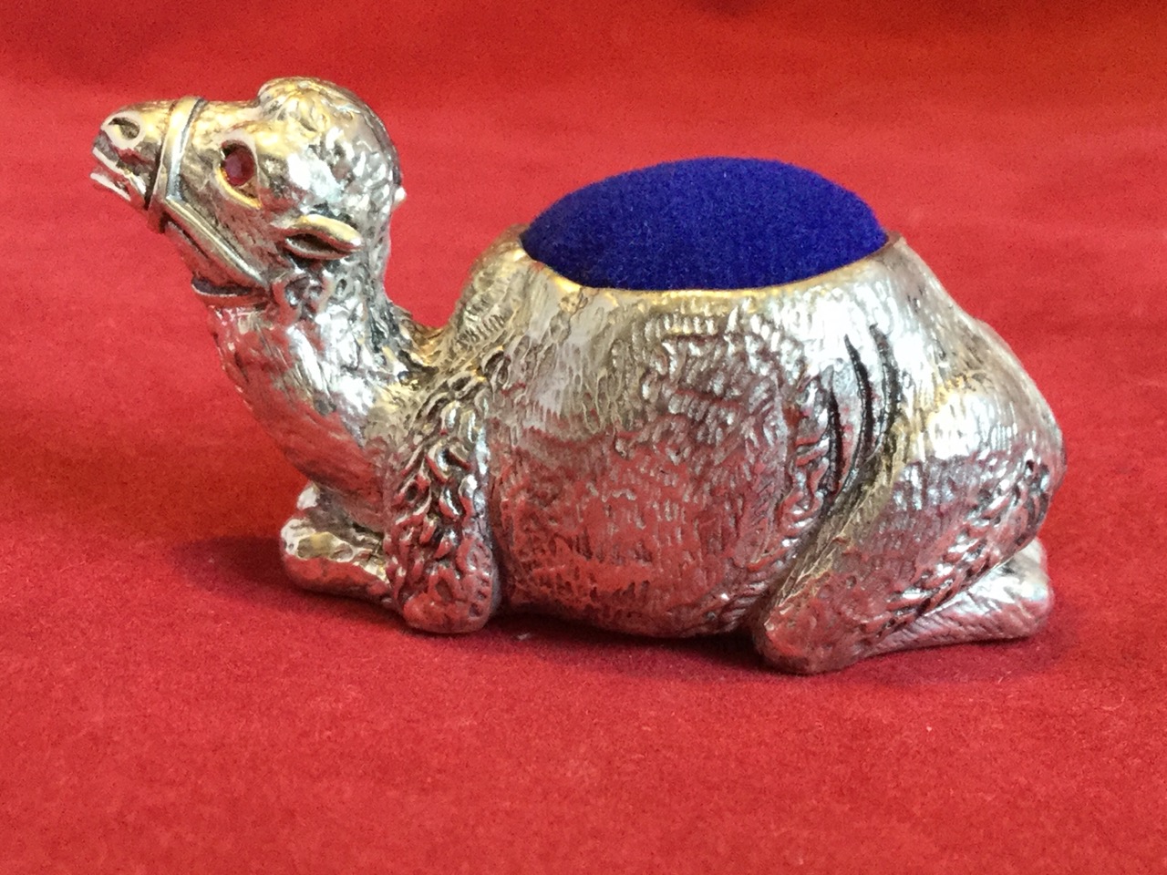A silver plated pin cushion cast as a seated camel having inlaid ruby eyes, the hump or back with - Image 2 of 3