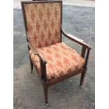 A late Victorian mahogany bergére armchair, the back & sides formerly caned, the scrolled arms on