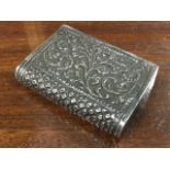A Victorian Indian silver vesta of book form with embossed foliate scrolled panels, having sprung