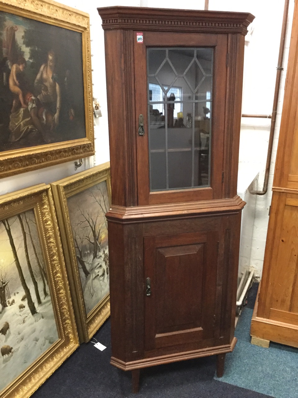 A mahogany corner cupboard with moulded dentil cornice above leaded glass door and a fielded