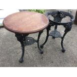 A pair of circular Victorian style cast iron tables, the foliate pierced aprons framing medusa