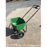 A push-along garden fertiliser spreader, the trolley with hand adjustable release valve.