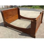 A mahogany sleigh bed, the panelled headboard & tailboard with turned top rails, having shaped