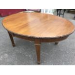 A late Victorian mahogany dining table, the oval top with flowerhead carved edge above a plain