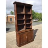 An Edwardian oak open bookcase, the top with moulded ogee cornice above two banks of eight
