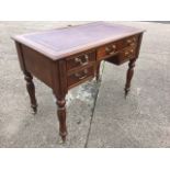 A Victorian style writing desk, the crossbanded moulded top with gilt tooled leather skiver above