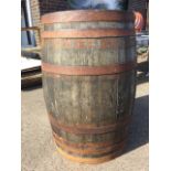 A 3ft oak barrel, the staves bound by six metal strap bands. (24in x 35in)