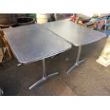 A pair of rectangular aluminium garden tables, the rounded tray tops on column supports with splayed