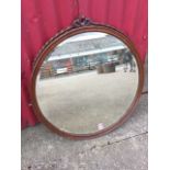 A circular Victorian mahogany mirror, with bevelled plate in moulded frame mounted with pieced