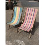 A striped canvas folding deck chair with beech frame; and another similar. (2)