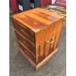 A square military style yew cabinet of three drawers having brass mounts, supported on a moulded