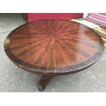 A circular William IV mahogany breakfast table, the segmented flame veneered top with rosewood