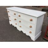 A reproduction painted pine chest of six long knobbed drawers, with rectangular moulded top and