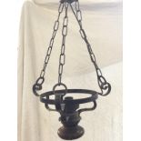 A wrought iron hanging light with three scrolled supports on chains, having turned hardwood bun