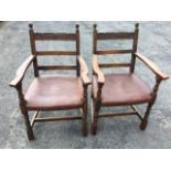 A pair of carved oak elbow chairs, the back rails with foliate scroll carved decoration, having