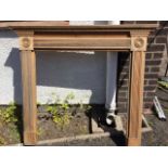 A pine chimneypiece with moulded dentil mantle shelf above a reeded frieze framed by turned