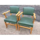 A pair of beech armchairs with upholstered backs & seats, having shaped arms, raised on square