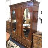 A late Victorian mahogany wardrobe with moulded cornice inlaid with dentil band above a pair of oval
