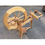 A 70s Ashford beech spinning wheel, with treadle action raised on three tapering shaped legs, the