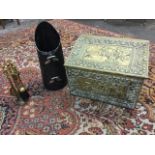 An embossed brass coal/log box with figural panels framed by foliate shell moulded borders; a