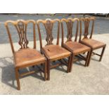 A set of four Chippendale style mahogany dining chairs, the scroll carved back rails above rosette