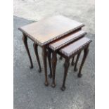 A nest of three mahogany tables, the rectangular gadroon carved tops on slender tapering cabriole