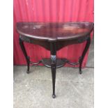 A stained late Victorian hall table, the D shaped moulded top above a frieze carved with floral