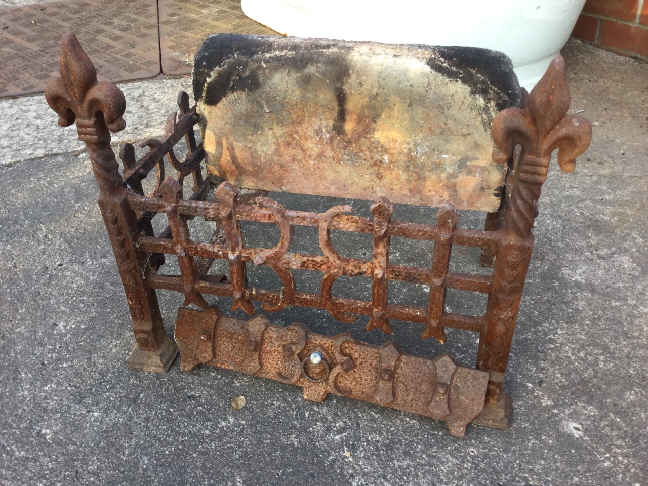 A rectangular wrought iron dog grate, having firebrick back and riveted trellis framed basket, the