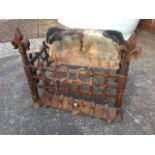 A rectangular wrought iron dog grate, having firebrick back and riveted trellis framed basket, the