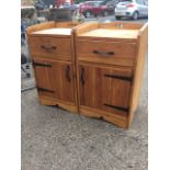 A pair of pine bedside cabinets with tray tops above drawers and boarded cupboards mounted with