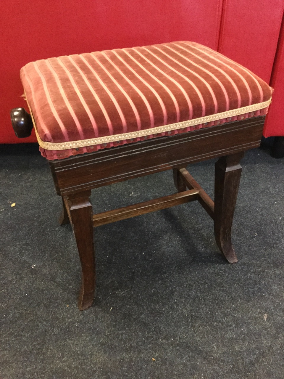 A rectangular late Victorian rosewood piano stool, the rise-and-fall adjustable upholstered seat