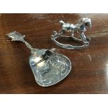 A German silver caddy spoon of shovel form embossed with scrolling, having shield amourial -