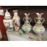 A pair of Japanese stoneware vases with scrolled handles, brightly enamelled with stylised