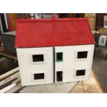 A childs painted dolls house with pitched roof, the front elevation opening as two hinged doors. (