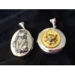 An oval silver locket mounted with a seated cat, the animal set with coloured stones to collar and