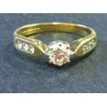 An 18ct gold diamond ring with single claw set stone, having three smaller diamonds inlaid into