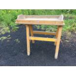 A Victorian pine dairy table, the tray top with angled sides supported on rectangular legs &