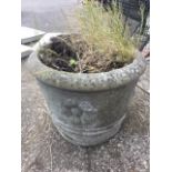 A circular composition stone tapering garden tub embossed with flowerheads. (17in x 13in)