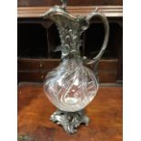 A Victorian claret jug cut with swirl bands to glass body, having silver plated mounts, the spout