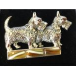 A silver brooch modelled as a pair of scottie dogs on a rectangular agate three panel band, having