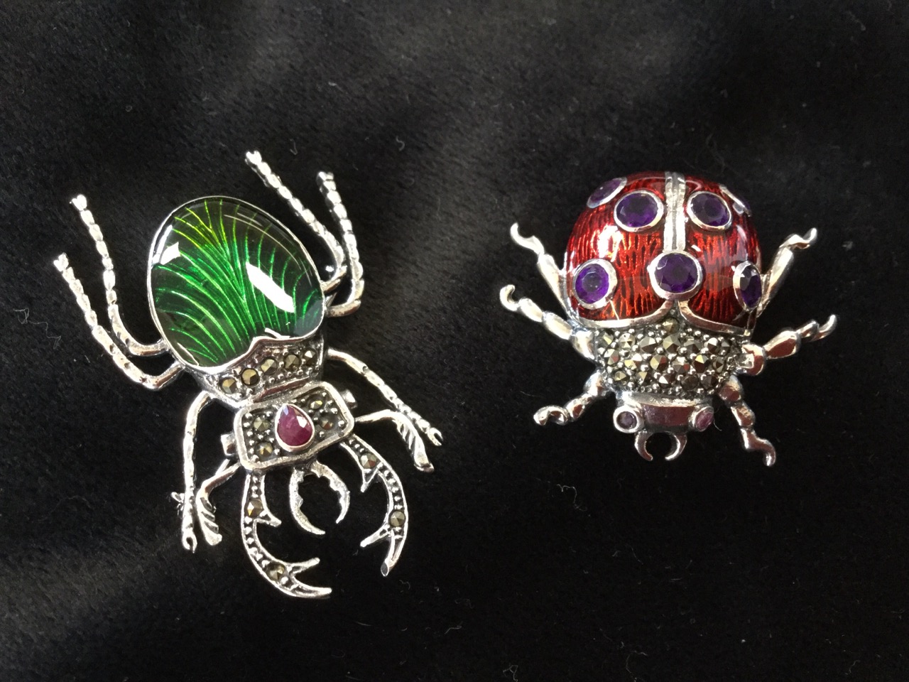 A silver ladybird brooch, the enamelled back set with amethysts having marcasites to thorax, with