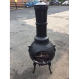 A cast iron chimera patio stove, the bulbous burning chamber having internal shelves, with