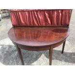 A nineteenth century D-shaped mahogany serving table, the back with brass rails supporting
