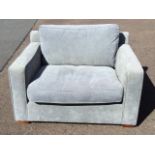 A large contemporary sofa type armchair, the wide seat with loose cushions in square upholstered
