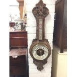 A Victorian carved walnut barometer with foliate scroll carved frame, the aneroid dial named John