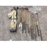 A collection of hickory shafted golf clubs with iron forged heads, some with leather grips, two wood