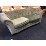 A button upholstered chesterfield sofa with deep padded back & arms above loose cushions, having