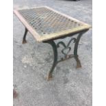 A rectangular garden table with interwoven style metal panel in wood frame on scroll cast sabre legs
